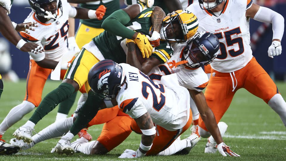 Denver's Pat Surtain II tackles the Packers wide receiver Malik Heath. - Tyler Schank/Getty Images