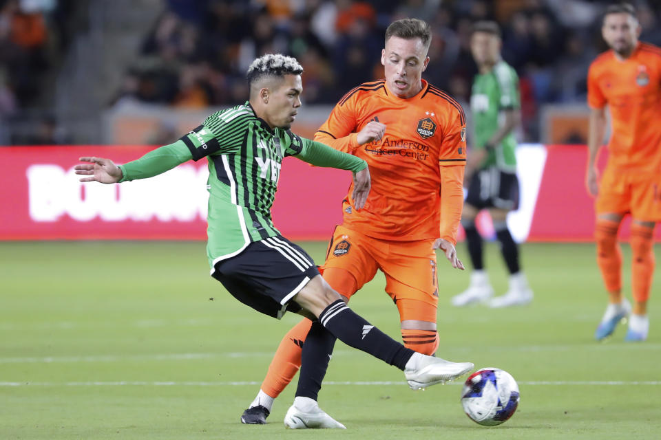 Austin FC midfielder Daniel Pereira, left, kicks the ball away in front of Houston Dynamo forward Corey Baird (11) during the second half of an MLS soccer match Saturday, March 18, 2023, in Houston. (AP Photo/Michael Wyke)