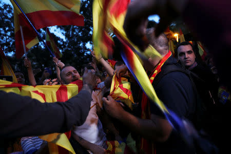 Protesters against a banned referendum on independence in Catalonia tear Esteladas (Catalan separatist flag) during a demonstration in Barcelona, Spain, September 22, 2017. REUTERS/Susana Vera