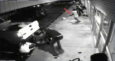 People are pictured outside Solo Insurance Services in St. Louis, Missouri in this still image capture from August 9, 2015 surveillance video footage in this August 11, 2015 St. Louis County Police Department handout photo. Police say the man indicated by the arrow is Tyrone Harris, who was later shot by police. REUTERS/St. Louis County Police Department/Handout