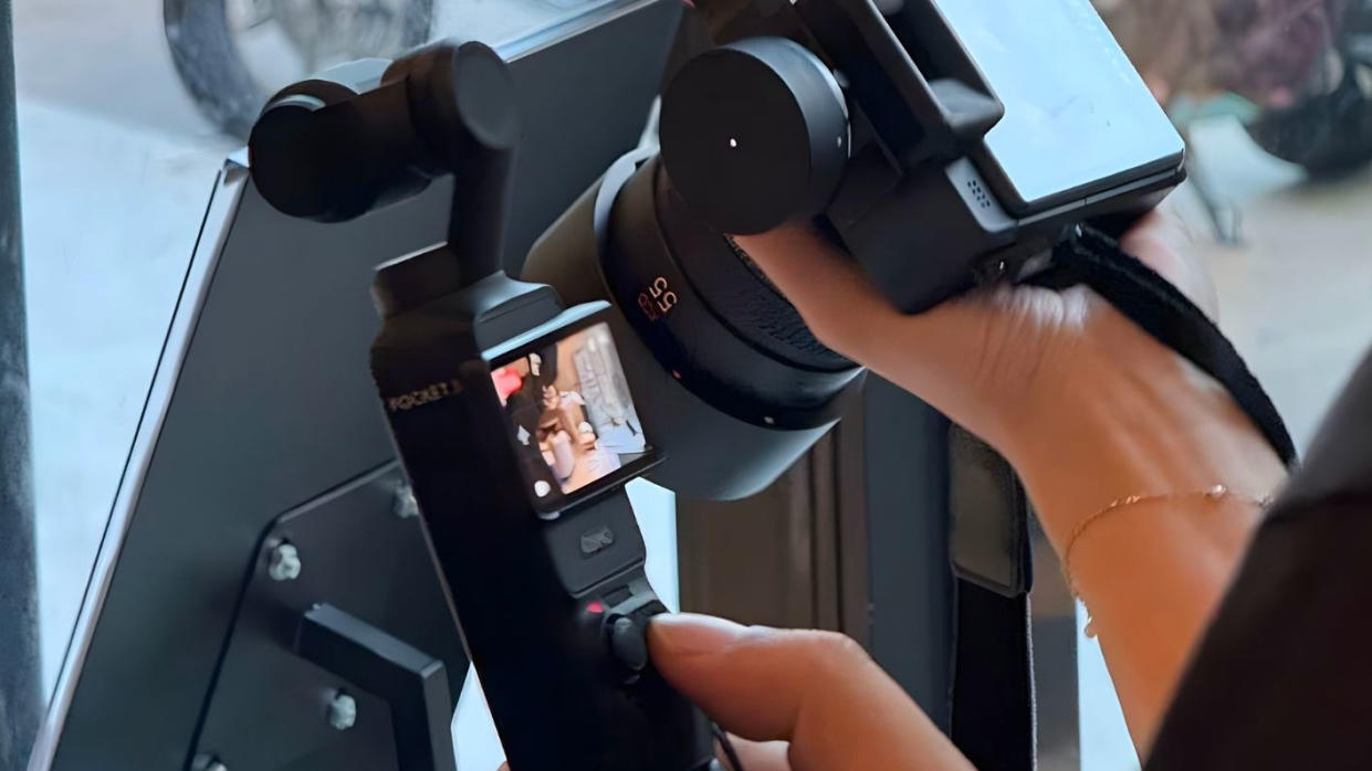  DJI Osmo Pocket 3 being held in front of another camera. 