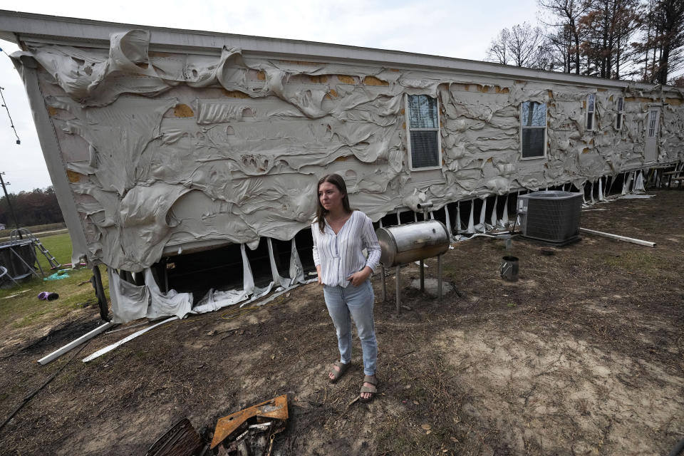 Lindsay Bustamante shows the damage to her home in the aftermath of a wildfire in Evans, La., Wednesday, Sept. 13, 2023. (AP Photo/Gerald Herbert)