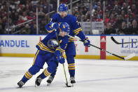 Buffalo Sabres defenseman Rasmus Dahlin, front, skates with the puck into the zone in front of Sabres right wing JJ Peterka during the second period of an NHL hockey game against the Montreal Canadiens in Buffalo, N.Y., Monday, March 27, 2023. (AP Photo/Adrian Kraus)