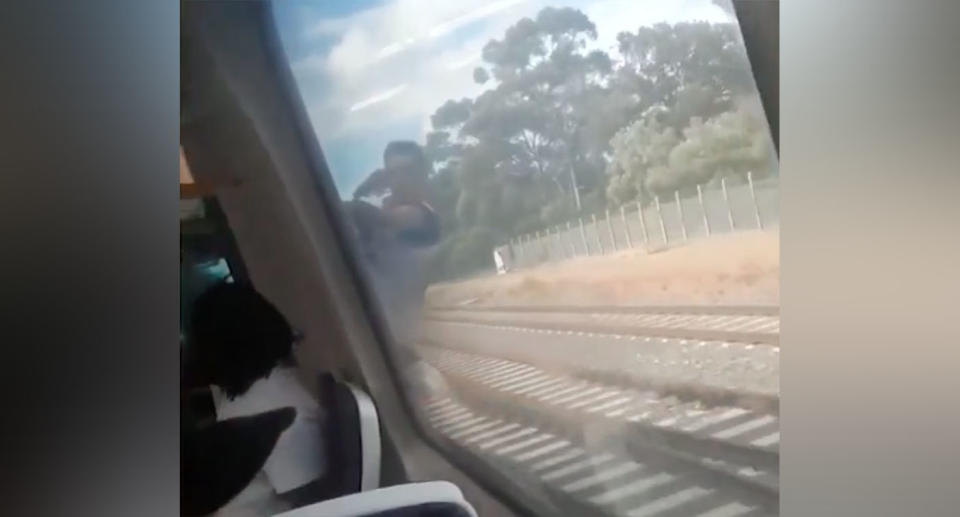 Shocked passengers watched in horror as a man diced with death while clinging from a speeding Adelaide train. Source: 7 News