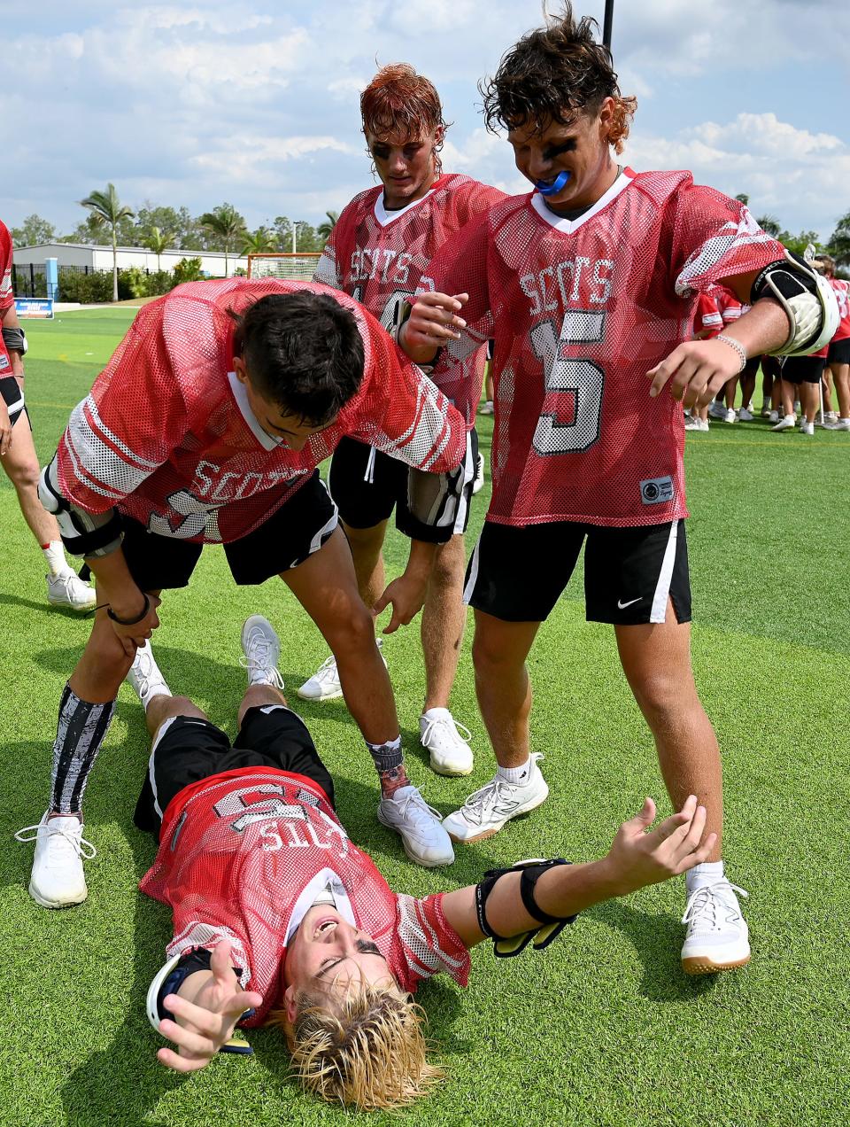 St. Andrew’s Connor Hofbauer (45) celebrates surrounded by his teammates Friday after winning their game against the Bolles School in a boys 1A lacrosse state championship matchup in Naples,.