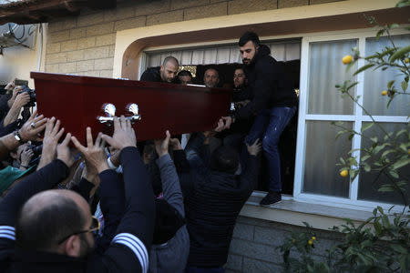 The coffin carrying the body of Aiia Maasarwe, 21, an Israeli student killed in Melbourne, is lifted out of a window from her home by friends and relatives ahead of her funeral in Baqa Al-Gharbiyye, northern Israel January 23, 2019. REUTERS/Ammar Awad