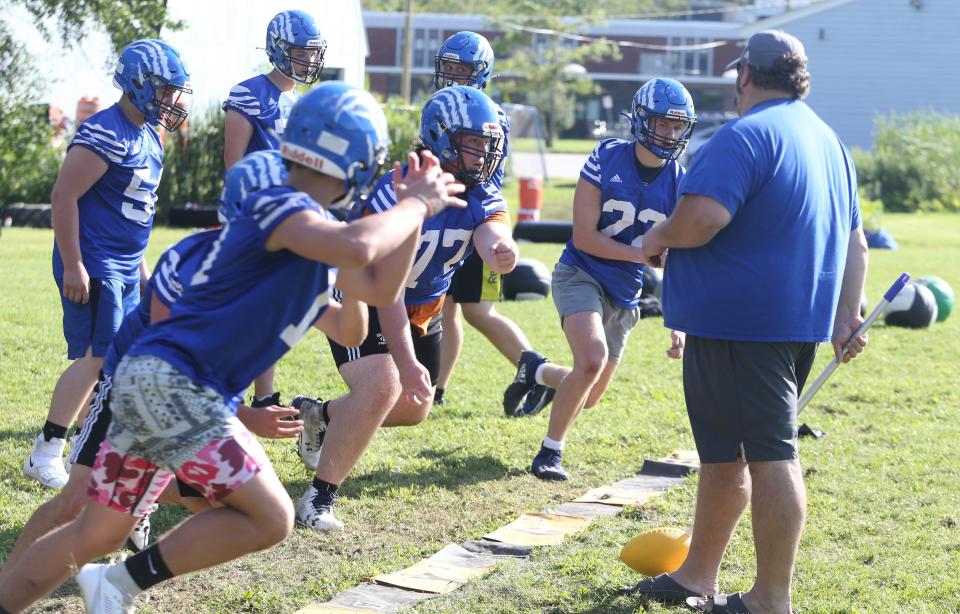 Somersworth High School head coach Jeremy Lambert goes over drills with linemen during the first day of practice for the fall 2023 season Friday, Aug. 11.