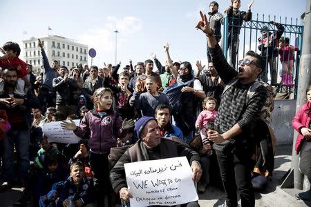 Stranded refugees and migrants shout slogans as they stage a protest demanding to be allowed to cross the Greek-Macedonian border at the port of Piraeus, near Athens, Greece, February 26, 2016. REUTERS/Alkis Konstantinidis