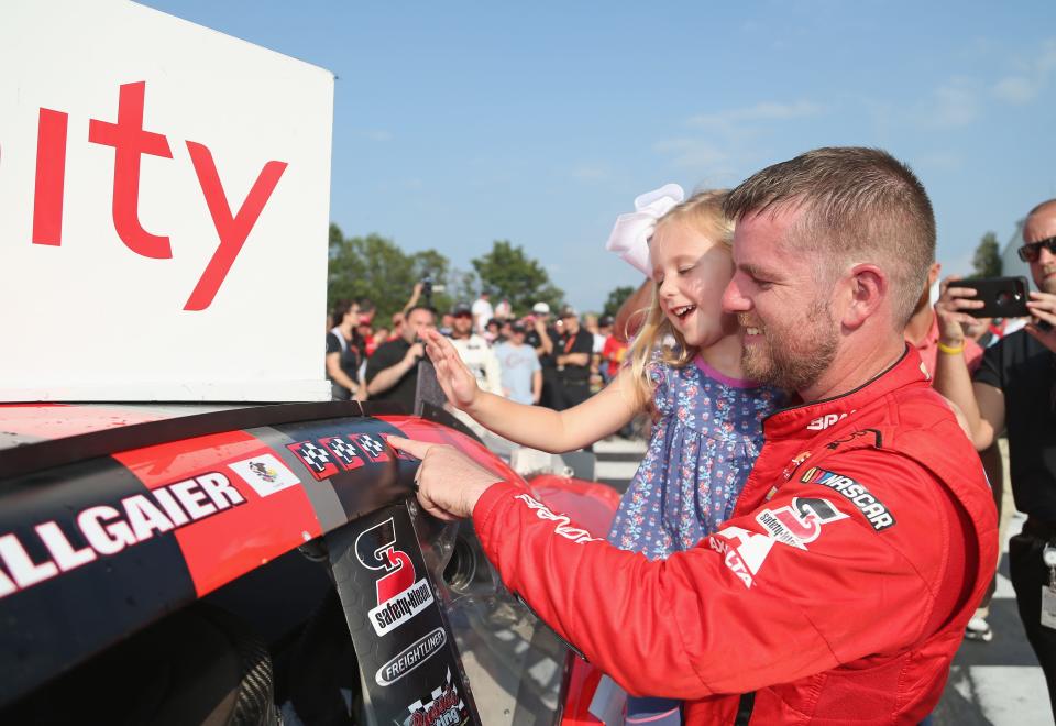 Justin Allgaier applies with winner's sticker with his daughter, Harper, after the 2018 Johnsonville 180.
