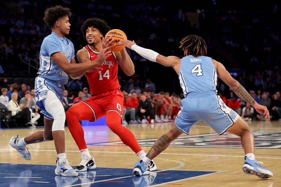 Dec 17, 2022; New York, New York, USA; Ohio State Buckeyes forward Justice Sueing (14) drives to the basket against North Carolina Tar Heels forward Puff Johnson (14) and guard R.J. Davis (4) during the first half at Madison Square Garden. Mandatory Credit: Brad Penner-USA TODAY Sports