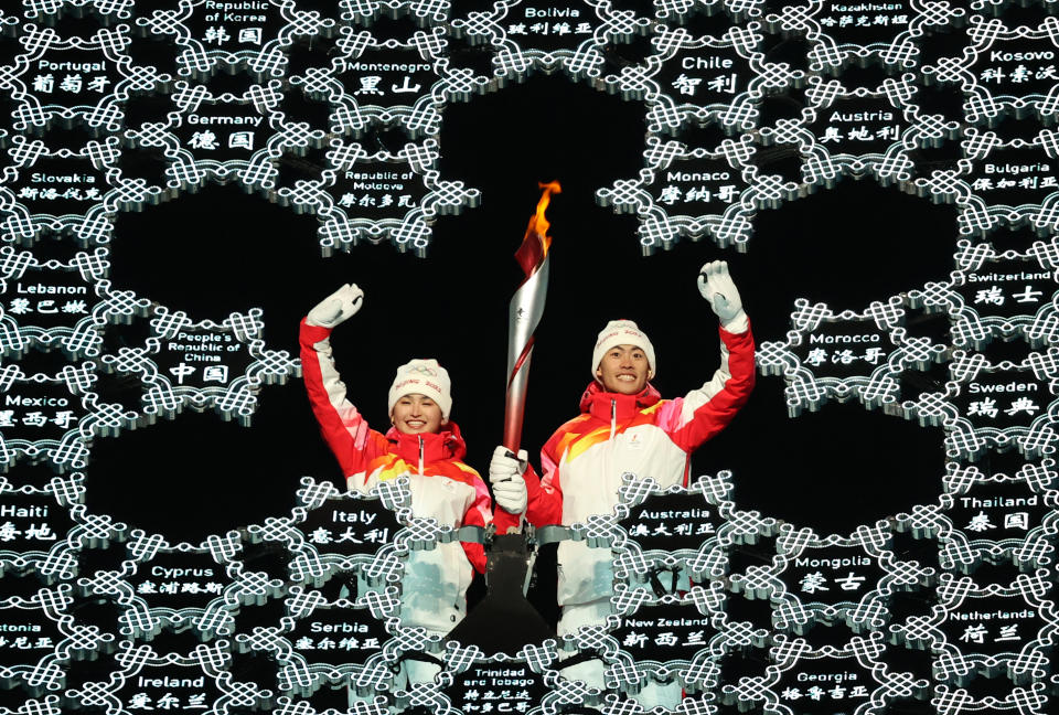 BEIJING, CHINA FEBRUARY 4, 2022: Chinese athletes Dinigeer Yilamujiang and Zhao Jiawen light the snowflake-shaped Olympic cauldron at the opening ceremony of the Beijing 2022 Winter Olympic Games at the National Stadium (also known as the Bird's Nest). Sergei Bobylev/TASS (Photo by Sergei Bobylev\TASS via Getty Images)