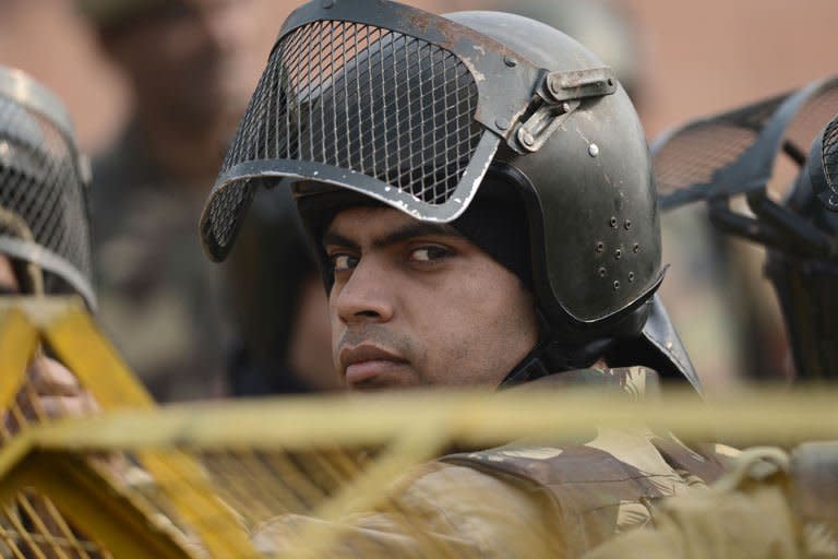 Indian riot police look on as they keep watch along a sealed-off road leading towards the landmark India Gate monument following weekend clashes between demonstrators and police in New Delhi on December 24, 2012. Indian Prime Minister Manmohan Singh has appealed for calm and vowed to protect women as police struggled to quell increasing outrage over sex crimes following the gang-rape of a student