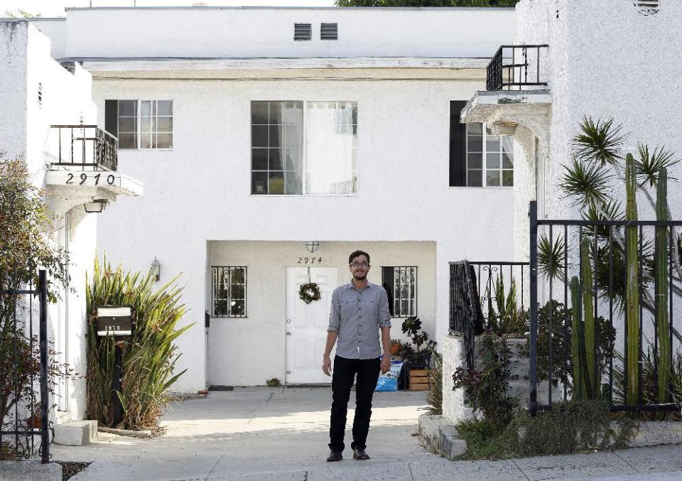 In this Thursday, March, 27, 2014 photo, Marc Caswell, who recently moved from San Francisco to Los Angeles, poses for a photo in front of his newly rented apartment in the Los Feliz district of Los Angeles. Rising rents in San Francisco compelled Marc Caswell to move to Los Angeles in September. (AP Photo/Damian Dovarganes)