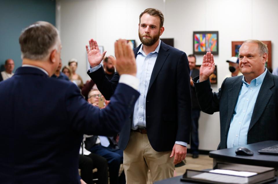 New Springfield Public Schools Board members Kelly Byrne (center) and Steve Makoski (right) are sworn in by Greene County Clerk Shane Schoeller during a school board meeting on Tuesday, April 12, 2022.