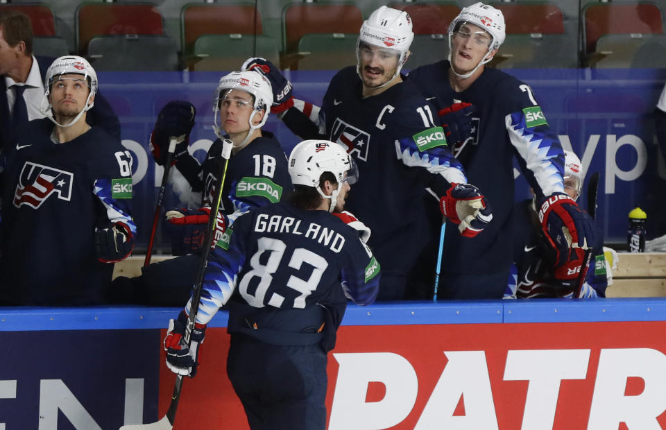 Conor Garland of the US, center, celebrates with teammates after scoring his side's sixth goal during the Ice Hockey World Championship quarterfinal match between the United States and Slovakia at the Arena in Riga, Latvia, Thursday, June 3, 2021.(AP Photo/Sergei Grits)