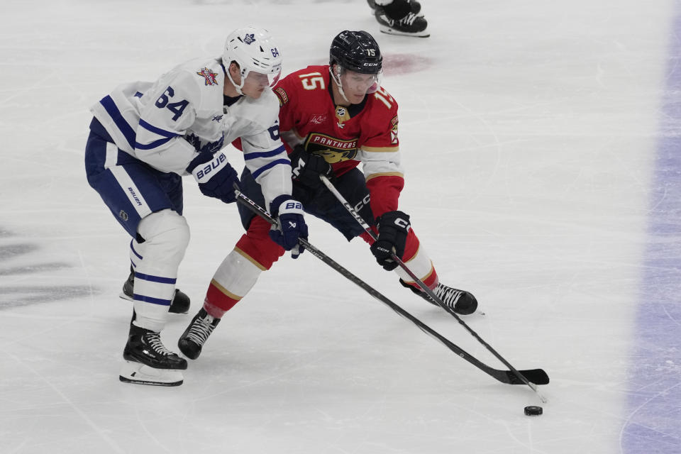 Florida Panthers center Anton Lundell (15) and Toronto Maple Leafs center David Kampf (64) go after the puck during the second period of an NHL hockey game, Thursday, Oct. 19, 2023, in Sunrise, Fla. (AP Photo/Marta Lavandier)