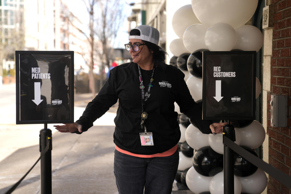 Mandy Gratz, an assistant manager at Good Day Farm, adjusts signs helping customers form lines outside the dispensary Friday, Feb. 3, 2023, in St. Louis. Recreational marijuana sales were allowed to begin on Friday in Missouri after the state's health department gave approval. (AP Photo/Jeff Roberson)