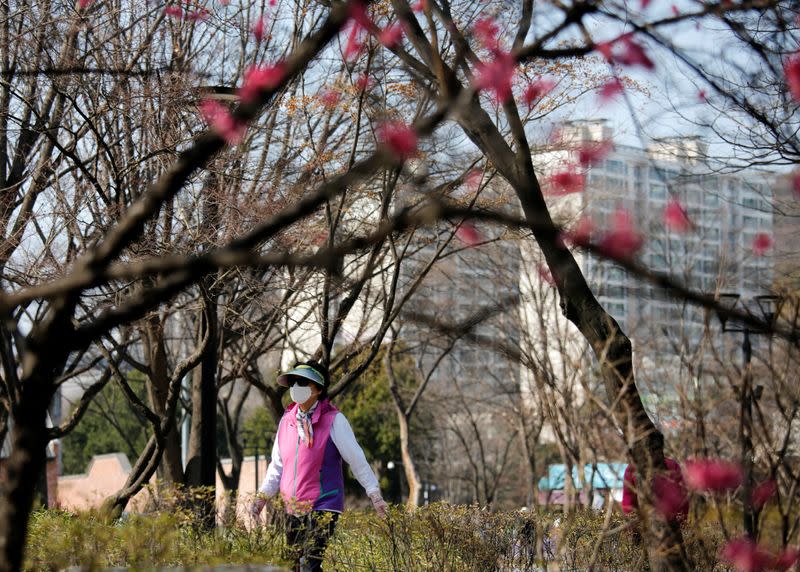 Woman, wearing mask to prevent getting coronavirus walks at park in Seoul