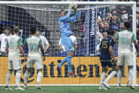 Austin FC goalkeeper Brad Stuver stops the ball as Alexander Ring (8), Sebastian Driussi (10), Julio Cascante (18) and Vancouver Whitecaps' Bjorn Utvik (15) watch during the first half of an MLS soccer match in Vancouver, British Columbia, on Saturday, May 4, 2024. (Ethan Cairns/The Canadian Press via AP)