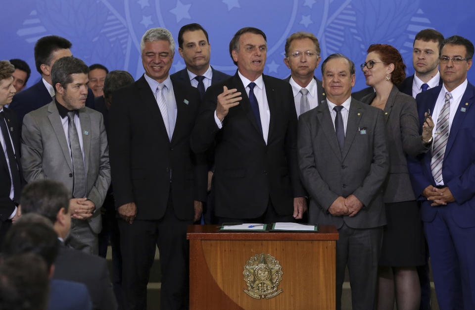 Brazil's President Jair Bolsonaro speaks during a signing ceremony where he signed a second decree that eases gun restrictions, at Planalto presidential palace in Brasilia, Brazil, Tuesday, May 7, 2019. The decree opens Brazil's market to guns and ammunition made outside of Brazil according to a summary of the decree. Gun owners can now buy between 1,000 -5,000 rounds of ammunition per year depending on their license, up from 50 rounds. Lower-ranking military members can now carry guns after 10 years of service. (AP Photo/Eraldo Peres)