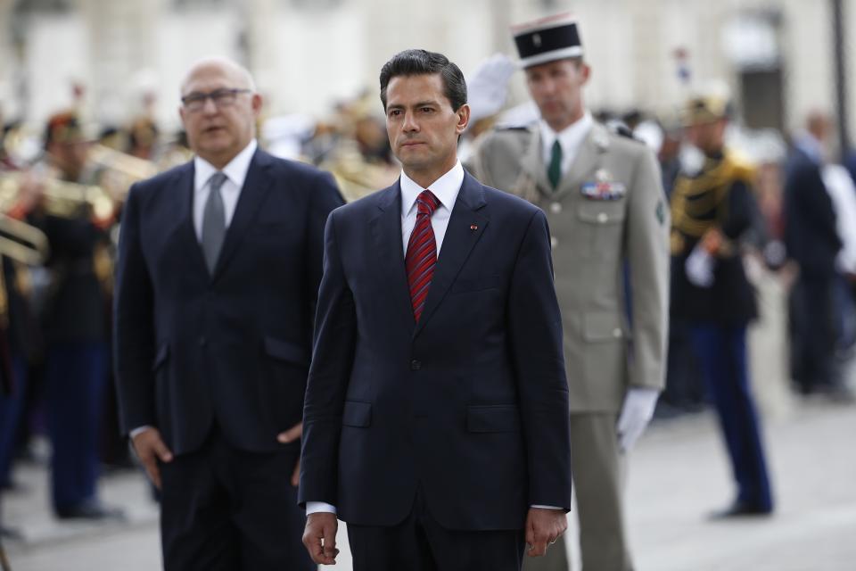 Mexico's President Enrique Pena Nieto and French Finance Minister Michel Sapin attend a wreath laying ceremony on the tomb of the unknown soldier at the Arc de Triomphe monument, on Bastille Day, in Paris