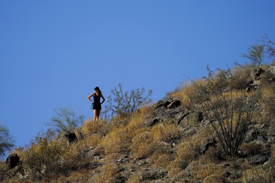 FILE - A hiker pauses during her hike early, July 10, 2023, in Phoenix. (AP Photo/Matt York, File)