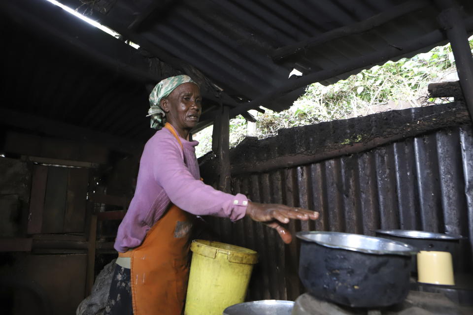 Jane Muthoni, 65, cleans up utensils at her home in Kiambu, Kenya Wednesday, May 22, 2024. Piles of firewood surrounded Jane Muthoni in her kitchen made of iron sheets. The roof, walls and wooden pillars were covered in soot. As she blew on the flame for tea, the 65-year-old was engulfed in smoke. She was unaware of the lasting toll on her health. (AP Photo/Andrew Kasuku)