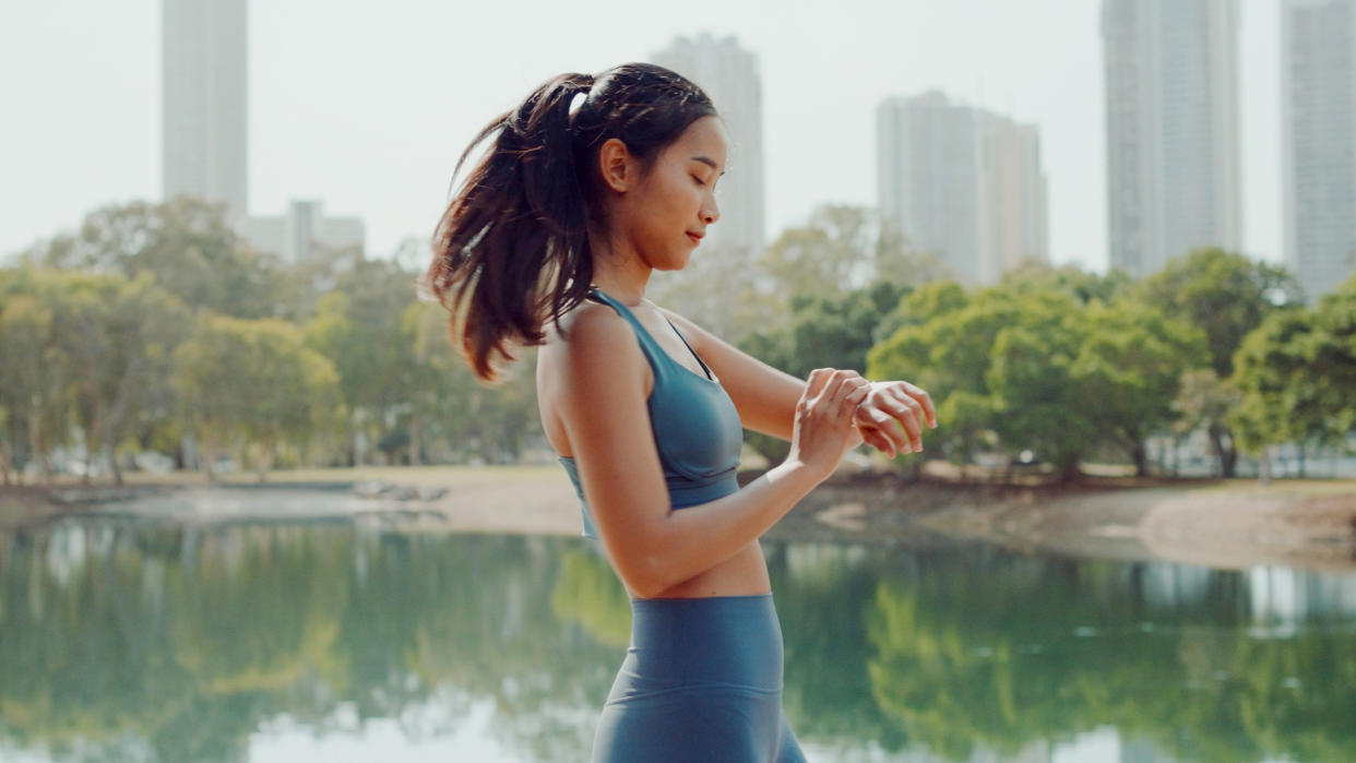  Woman using sports watch during workout. 