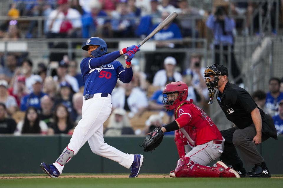 Los Angeles Dodgers' Mookie Betts (50) singles during the first inning of a spring training baseball game against the Los Angeles Angels in Phoenix, Tuesday, March 5, 2024. (AP Photo/Ashley Landis)