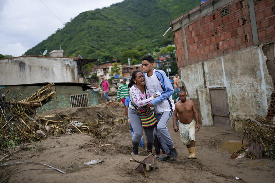 A woman cries as she searches for a missing relative in a flooded area in Las Tejerias, Venezuela, Sunday, Oct. 9, 2022. Days of heavy rains caused flash floods and overflowed a river. (AP Photo/Matias Delacroix)