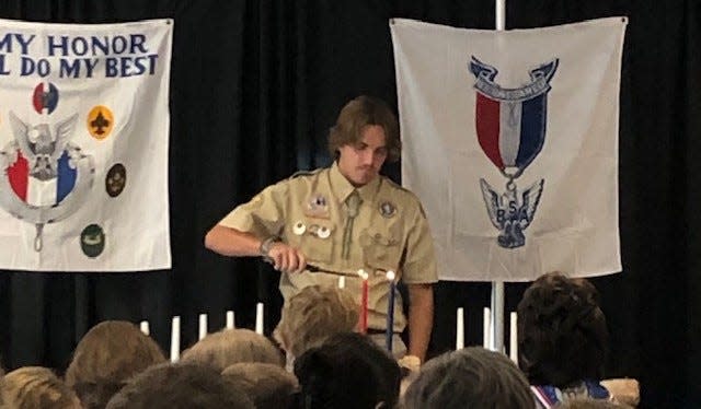 Wells High School senior Wilson Clough lights candles at a recent Scouts Eagle ceremony. Clough is trying to earn his Eagle Scout badge by organizing a project called the Friendship Festival and Walk to be held Sunday, Oct. 22, from 10 a.m. to 4 p.m., at the Wells Junior High School track.