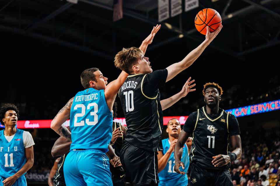 UCF freshman Mintautas Mockus (10) attempts a layup at the basket as Florida International's Petar Krivokapic defends.