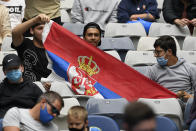 Serbian fans hold up their flag to support Laslo Djere of Serbia against Denis Shapovalov of Canada during their first round match at the Australian Open tennis championships in Melbourne, Australia, Monday, Jan. 17, 2022. (AP Photo/Andrew Brownbill)