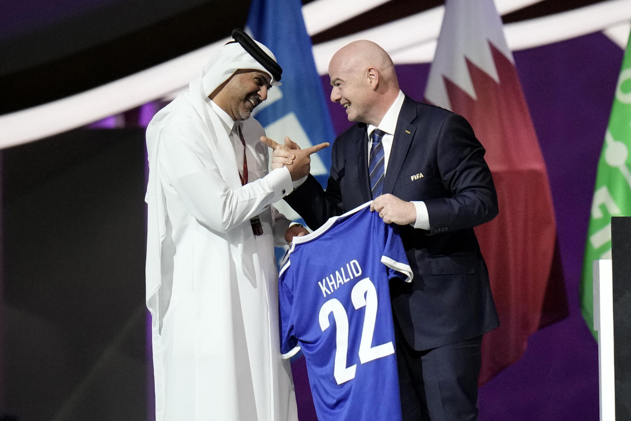 Prime Minister of the State of Qatar, Khalid Bin Khalifa Bin Abdulaziz Al Thani, left, receives a gift from FIFA President Gianni Infantino during the FIFA congress at the Doha Exhibition and Convention Center in Doha, Qatar, Thursday, March 31, 2022. (AP Photo/Hassan Ammar)