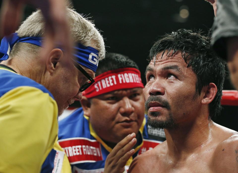 Manny Pacquiao, from the Philippines, right, listens to his trainer Freddie Roach, left, during their welterweight title fight on Saturday, May 2, 2015 in Las Vegas. (AP Photo/John Locher)