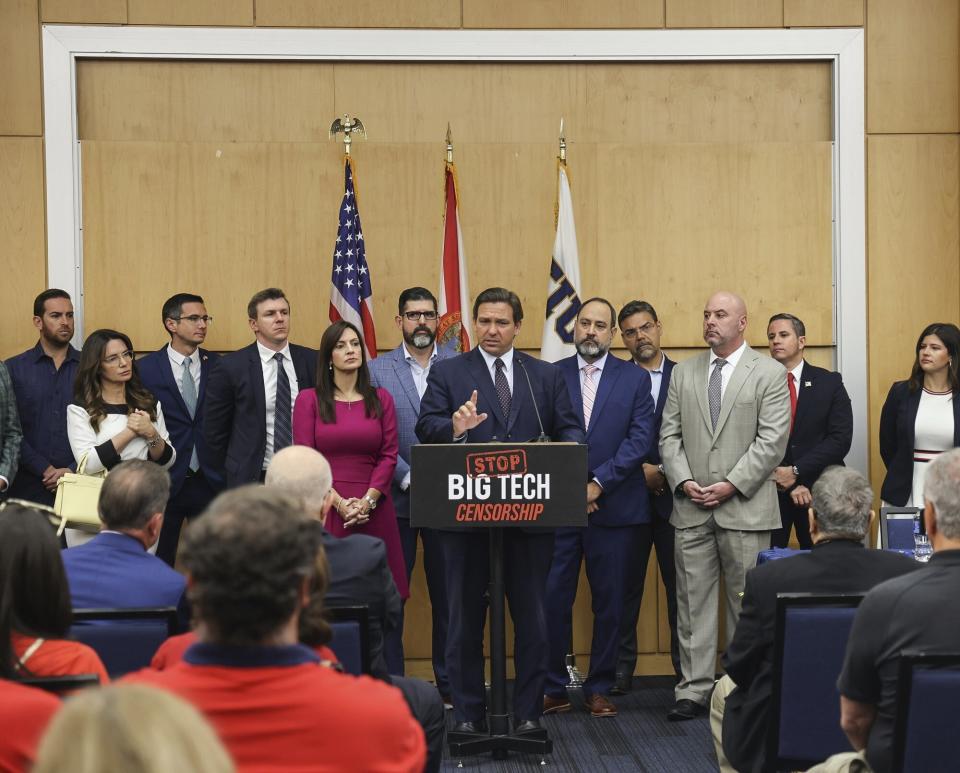 Florida Gov. Ron DeSantis, center, gives his opening remarks flanked by local state delegation members prior to signing legislation that seeks to punish social media platforms that remove conservative ideas from their sites, inside Florida International University's MARC building in Miami on Monday, May 24, 2021. (Carl Juste/Miami Herald via AP)