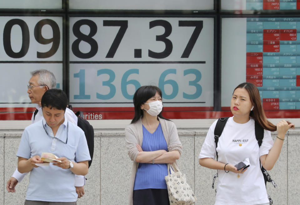 People stand by an electronic stock board of a securities firm in Tokyo, Tuesday, June 18, 2019. Stocks in Asia mostly advanced Tuesday ahead of interest rate decisions by the U.S. Federal Reserve and other central banks. (AP Photo/Koji Sasahara)