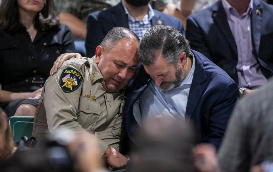 Uvalde County Sheriff Ruben Nolasco, left, is comforted by U.S. Sen. Ted Cruz during a vigil held in honor of the lives lost at Robb Elementary school at the Uvalde County Fairplex Arena in Uvalde, Texas, Wednesday, May 25, 2022. (Josie Norris/The San Antonio Express-News via AP) (Josie Norris/The San Antonio Express-News via AP)