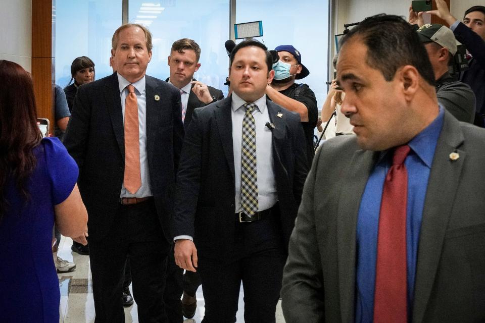 Ken Paxton, left, arrives to the 185th District Court for Friday's hearing in his securities fraud case.