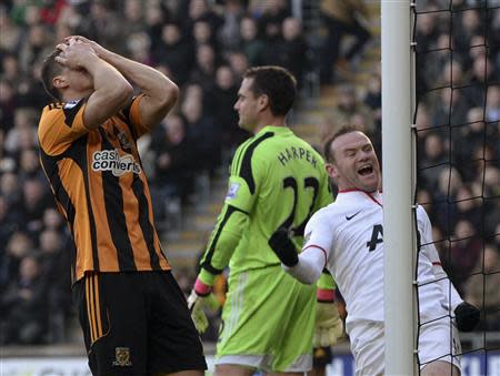 Hull City's James Chester (L) reacts after scoring an own goal as Manchester United's Wayne Rooney celebrates during their English Premier League soccer match at the KC Stadium in Hull, northern England December 26, 2013. REUTERS/Nigel Roddis