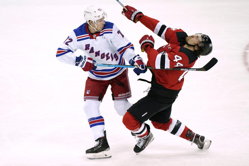 New York Rangers center Filip Chytil (72) uses his stick to fend off New Jersey Devils left wing Miles Wood (44) during the first period of an NHL hockey game, Thursday, March 4, 2021, in Newark, N.J. Chytull was penalized for the play. (AP Photo/Kathy Willens)