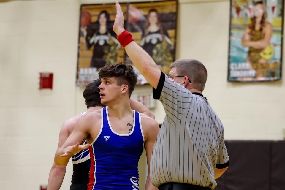 Jacob Lyons looks to the Mustang faithful after securing his win and having his arm raised by the referee.