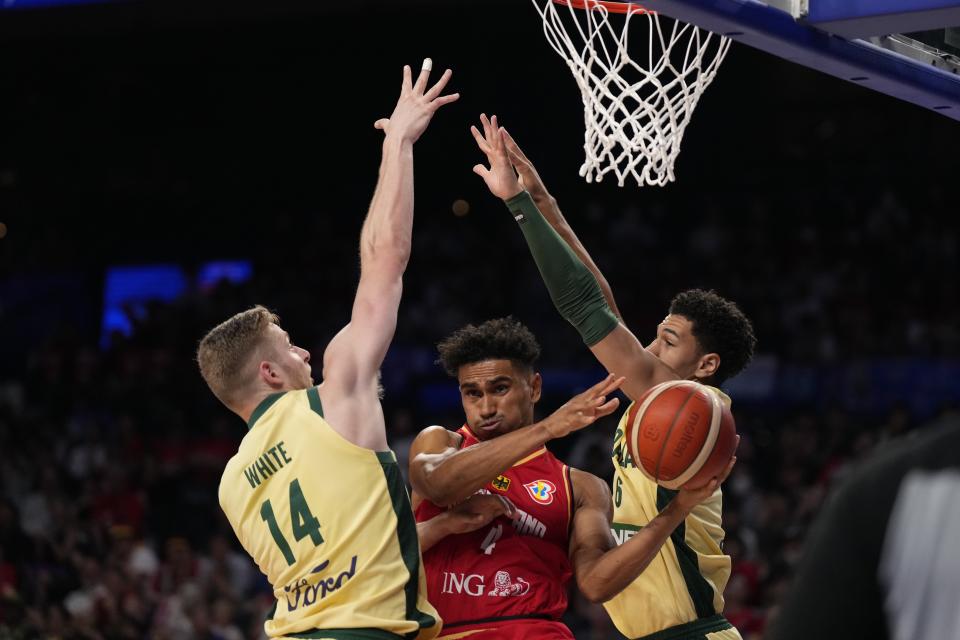 Germany guard Maodo Lo (4) tries to pass the ball against Australia forward Jack White (14) and forward Josh Green (6) in the second half of the Basketball World Cup group match in Okinawa, southern Japan, Sunday, Aug. 27, 2023. (AP Photo/Hiro Komae)