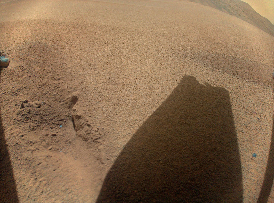 At the end of its 72nd and final flight in January 2024, Ingenuity dropped out of contact with flight controllers and one or more rotor blades was damaged, presumably due to an off-kilter landing. This photo, taken by a camera on the helicopter, shows the shadow of a damaged blade. / Credit: NASA