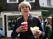 <p>Prime Minister Theresa May struggles to eat chips on the campaign trail (Getty Images) </p>