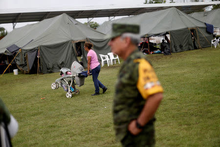 A woman pushes a stroller past tents at a shelter set up by the army in Jojutla de Juarez, Mexico September 21, 2017. REUTERS/Edgard Garrido