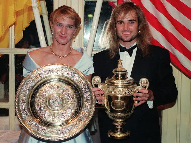 <p>David Giles - PA Images/PA Image/Getty</p> teffi Graf and Andre Agassi with their trophies at the post Wimbledon Dinner