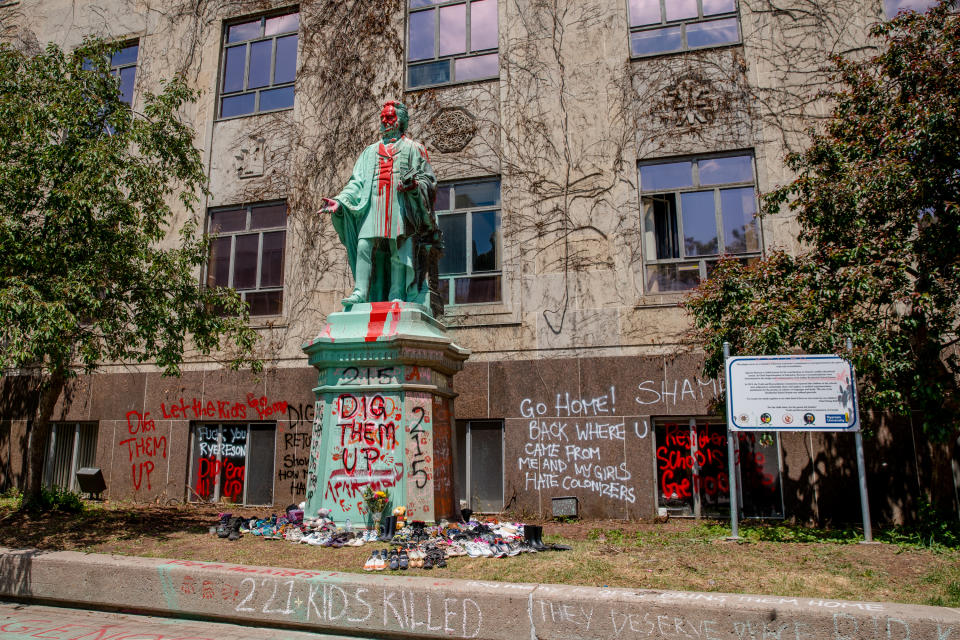 <p>Shoes were laid around the statue of Egerton Ryerson at Ryerson University as a memorial following the discovery of 215 bodies of students from residential schools in Kamloops, British Columbia. (Photo by Shawn Goldberg/SOPA Images/LightRocket via Getty Images)</p> 