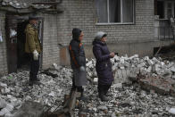 Local residents react near the destroyed house after recent Russian air strike in Chasiv Yar, Ukraine, Sunday, Nov. 27, 2022. Shelling by Russian forces struck several areas in eastern and southern Ukraine overnight as utility crews continued a scramble to restore power, water and heating following widespread strikes in recent weeks, officials said Sunday. (AP Photo/Andriy Andriyenko)
