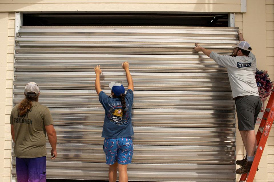 Volunteers place hurricane shutters at the Cedar Key Fire Station ahead of the arrival of Hurricane Idalia, in Cedar Key, Florida on Tuesday (REUTERS)